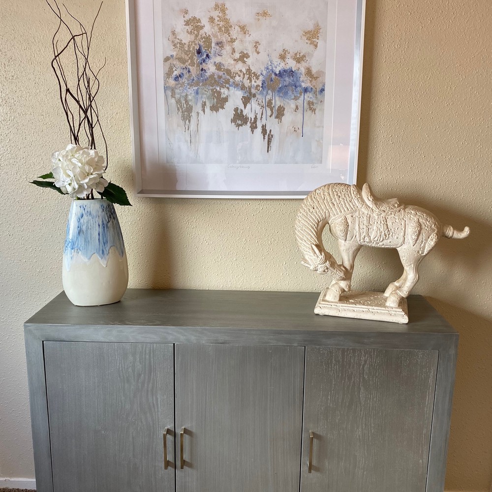 Console table with blue and white vase, and sculptured horse decoration.. Blue and white artwork.