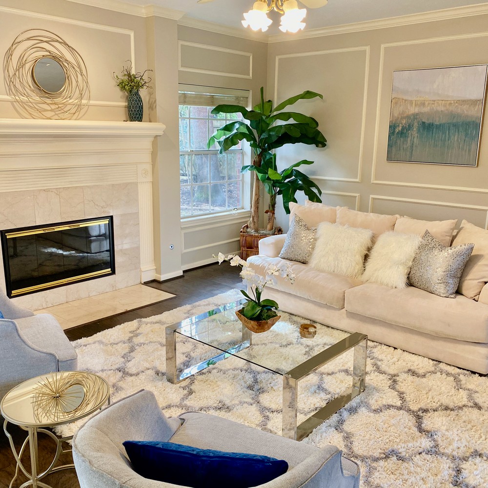 Living room with white fireplace and gold mirror.