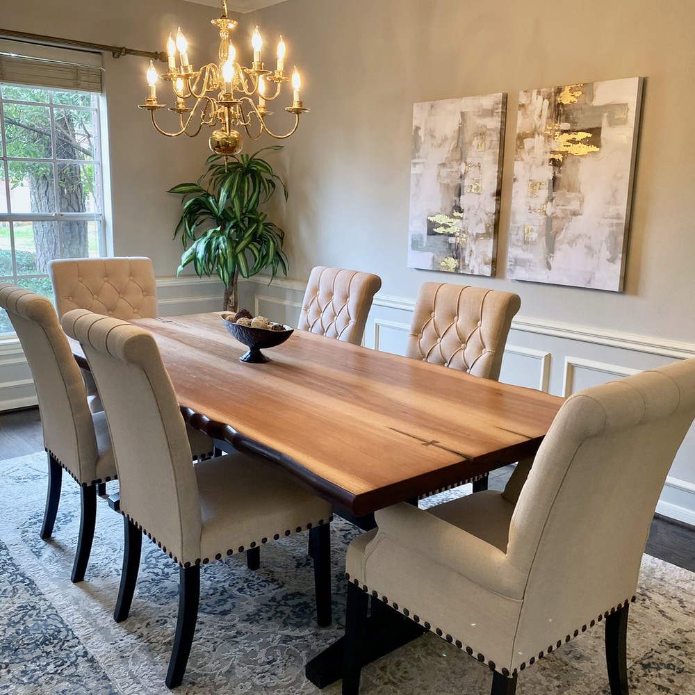 Dining room with patterned rug. Living edge dining table with six white chairs.