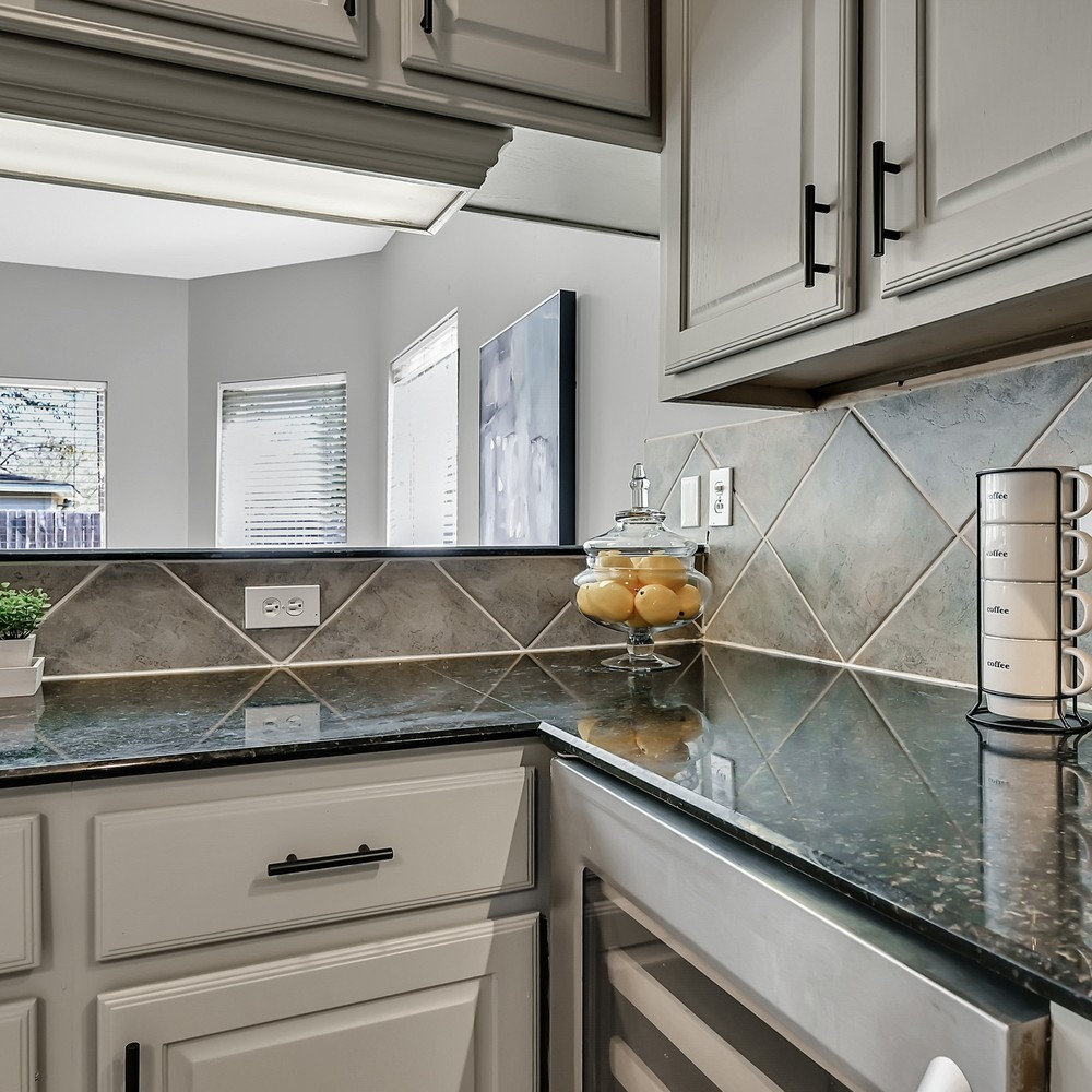 Kitchen was coffee cups and lemons displayed on counter top.