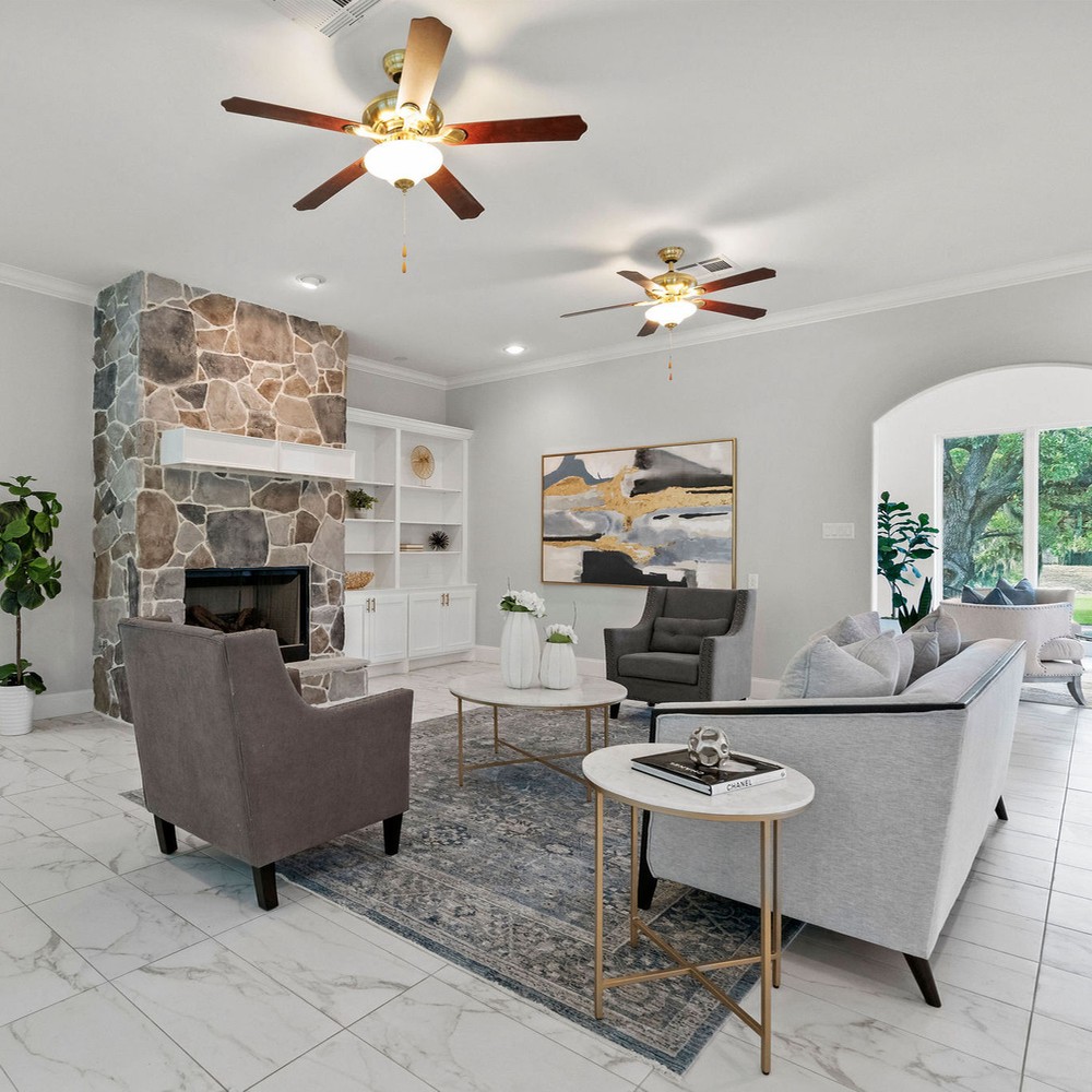 Living room with fireplace shown. Two chairs on either side of sofa.