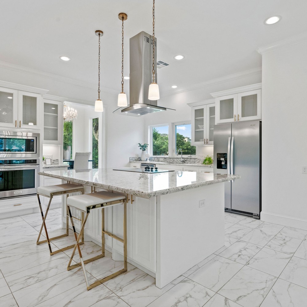 Kitchen island with two white and gold barstools.