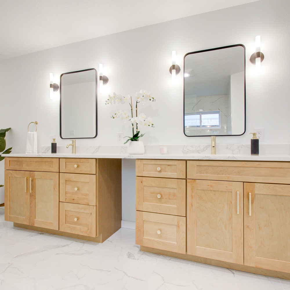 White bathroom with light wood cabinets.