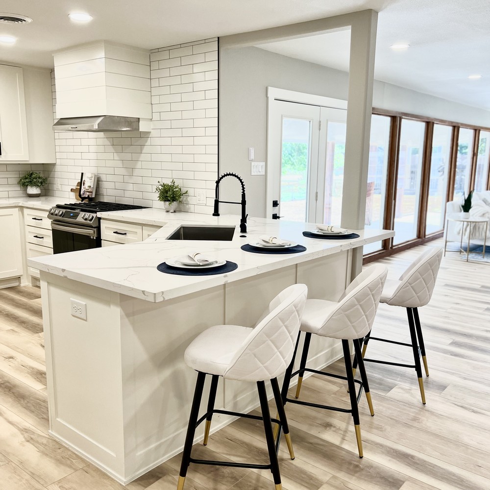 Kitchen with white barstools and white granite.