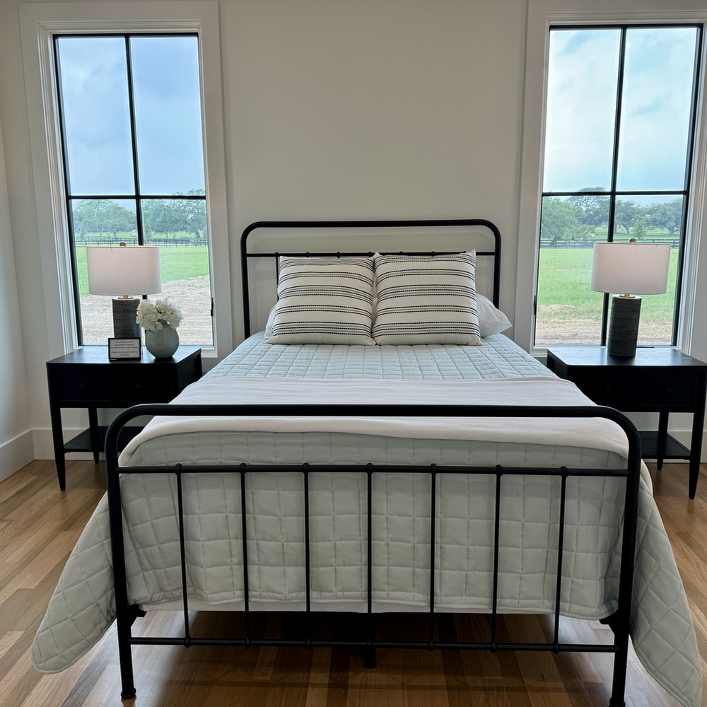 Round Top, TX Home Staging Secondary Bedroom with black metal bedframe.
